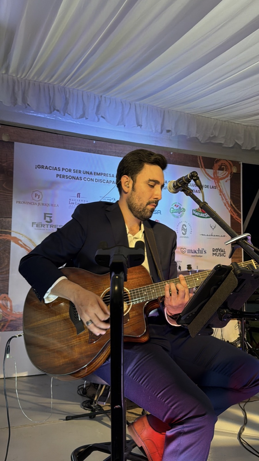 Adrián Eugenio interpreta guitarra durante un evento.