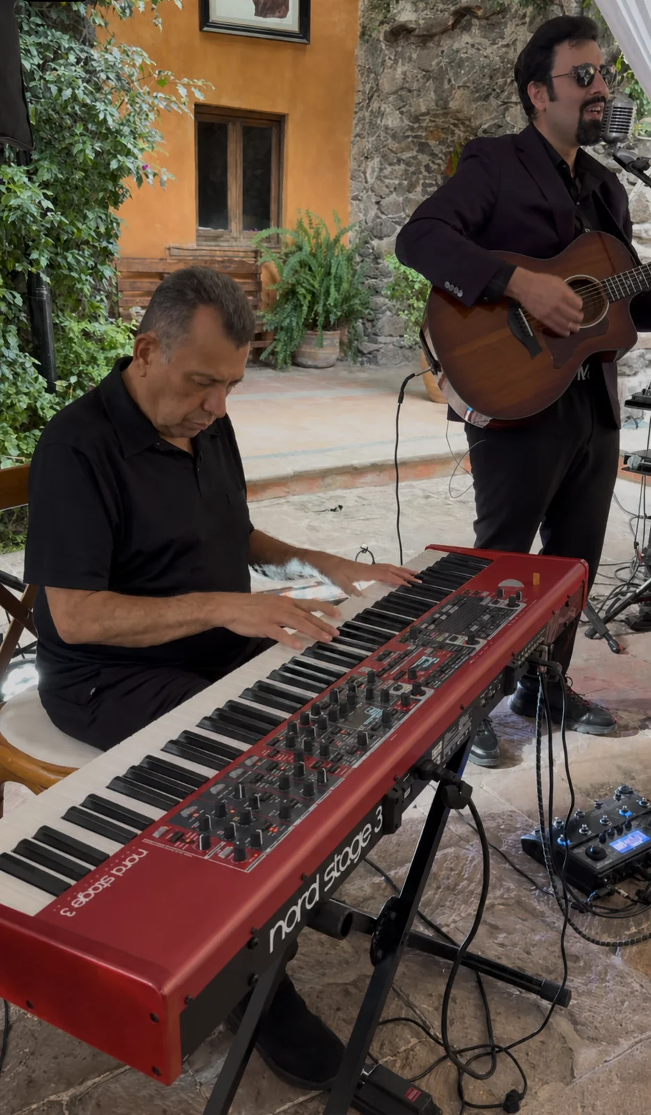 Músicos durante una presentación con guitarra y teclado.