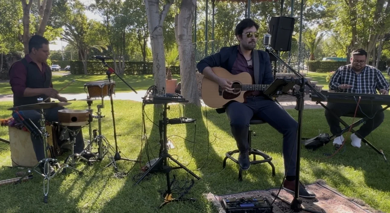 Trío acústico durante una presentación al aire libre.