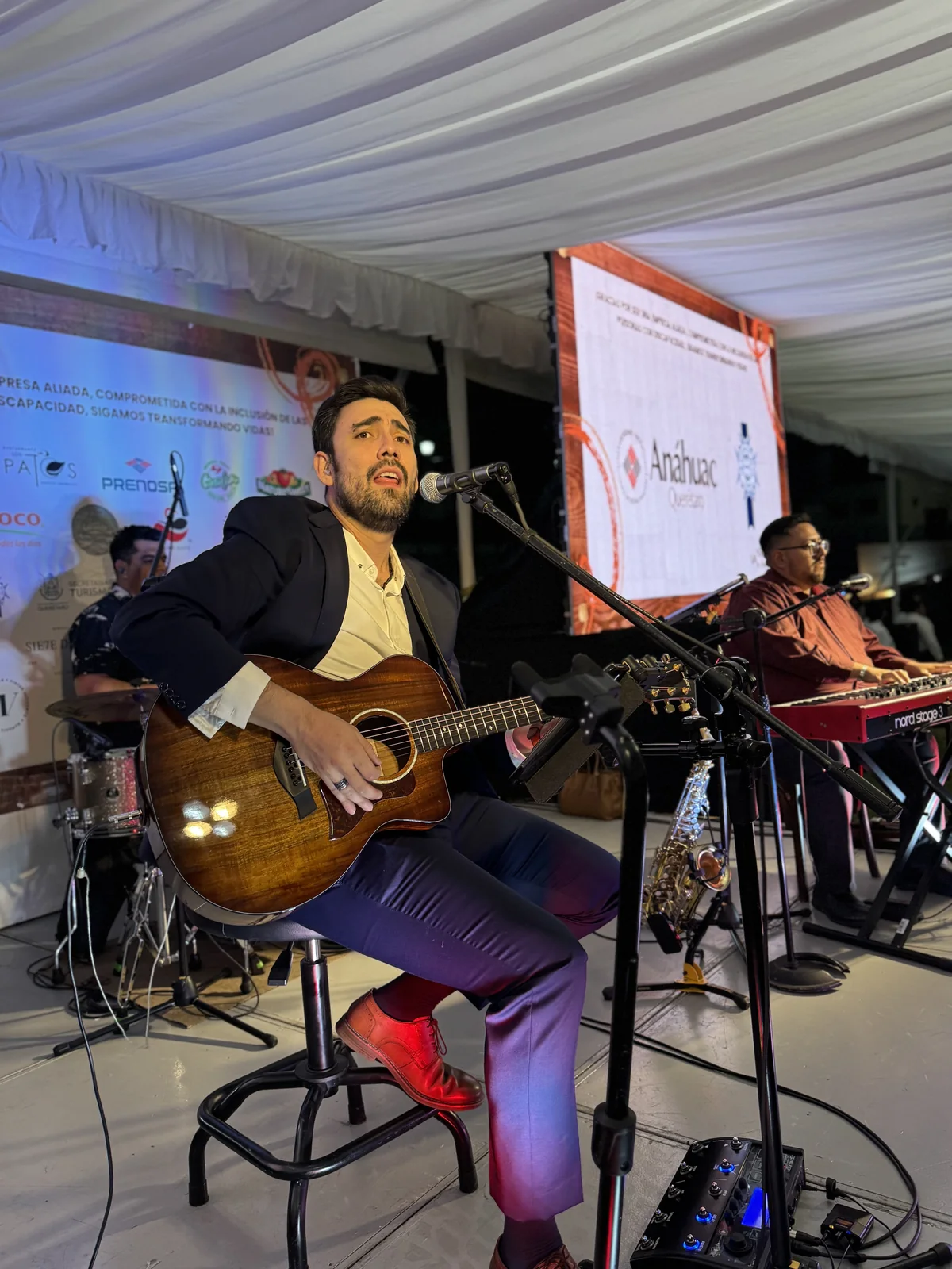 Adrián Eugenio interpreta guitarra durante un evento corporativo.